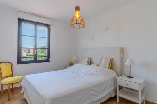 una camera da letto bianca con un letto e una finestra di Superbe maison neuve proche centre-ville et plage pour 4 personnes a Neufchâtel-Hardelot