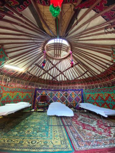 a room with a yurt with beds and a ceiling at Agyn guest house in Karakol