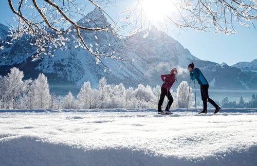 a man and woman cross country skiing in the snow at Sporthotel Schönruh in Ehrwald