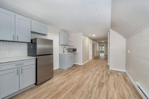 a large kitchen with white cabinets and a wooden floor at Perfect Private Unit in Passaic in Passaic