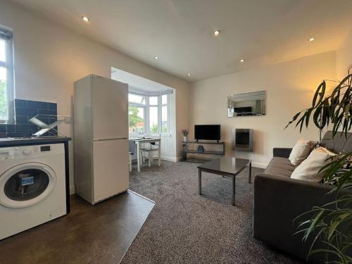 a living room with a couch and a refrigerator at Kingsbury Apt 2 in Birmingham