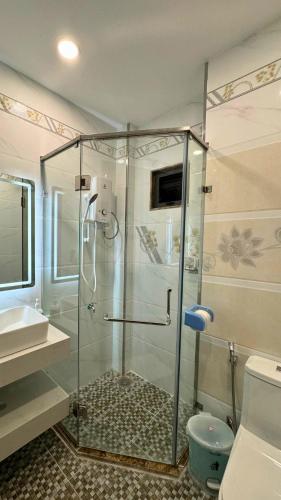 a bathroom with a shower and a toilet and a sink at Luala Home in Ho Chi Minh City
