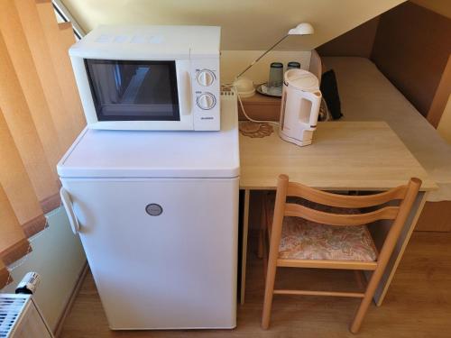 a small kitchen with a microwave on top of a refrigerator at Třílůžkový pokoj Pension Kubů in Špindlerův Mlýn