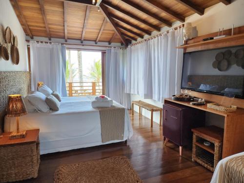 a bedroom with a bed and a large window at Pousada Vila do Mar in Caraíva