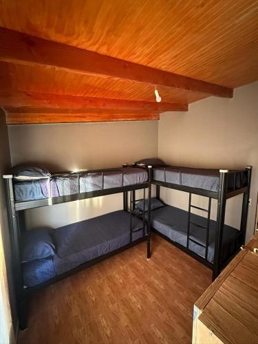 two bunk beds in a room with wooden ceilings at Xperience Hostel in San Pedro de Atacama