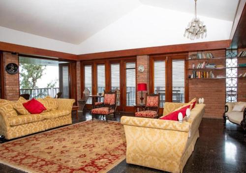 a living room with two couches and a rug at Tranquility Estate in Kingston