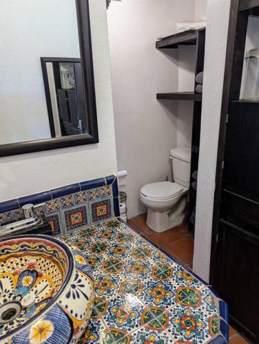 a bathroom with a toilet and a mosaic floor at Experience Guanajuato's Magic from Casa Mirador! in Guanajuato