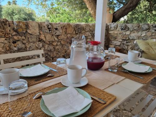 a table with plates and cups and a bottle of milk at Trulli Di Spinaruta in Grottaglie