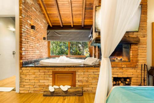 グラマドにあるHotel Cabanas Tio Müllerのレンガの壁のバスルーム(バスタブ付)