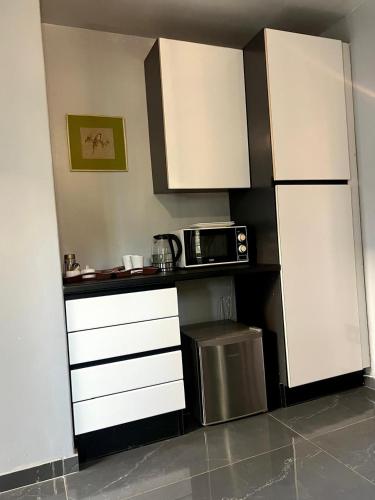 a kitchen with white cabinets and a microwave at The Concept in Centurion