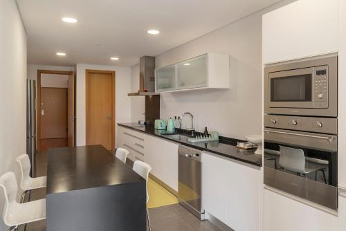 a kitchen with a counter top and a microwave at Piscina fantástica no centro da cidade! in Funchal