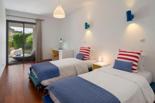 a bedroom with two beds and a balcony at Piscina fantástica no centro da cidade! in Funchal