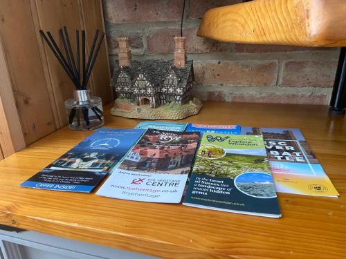 four books sitting on top of a wooden table at East Cliff Folkestone Guest Suite With Own Entrance in Folkestone