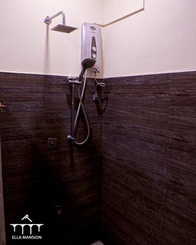 a bathroom with a shower with a phone on the wall at Ella Mansion in Ella
