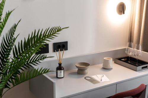 een wit bureau met een fles wijn en een plant bij Catalog Boutique Rooms Cluj-Napoca in Cluj-Napoca