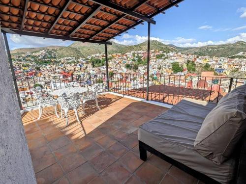 einen Balkon mit einem Tisch und Stühlen sowie Stadtblick in der Unterkunft Spacious Studio Boasting Breathtaking Views in Guanajuato