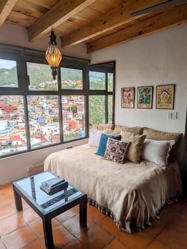 a living room with a couch and a table at Spacious Studio Boasting Breathtaking Views in Guanajuato
