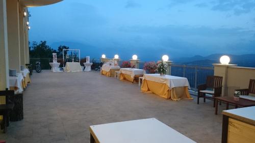 a room with tables and chairs on a balcony at Hotel Sette E Mezzo in Castelluccio Superiore