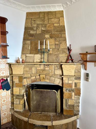 a stone fireplace with candles on top of it at Άκρη του κόσμου in Samos
