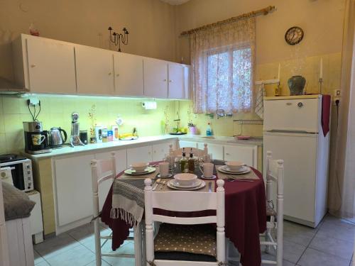 a kitchen with a table with chairs and a refrigerator at Mary's house in Kyparíssion