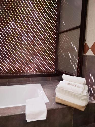 a bathroom with a tub and towels on a counter at La Teresita Hotel Boutique in Salta