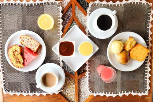 a table with plates of food and cups of coffee at Mirante de Lençóis in Lençóis