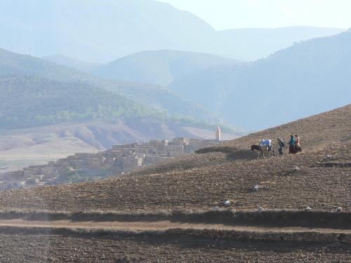 a group of people walking up a hill with a mountain at Tigmi Nomade in Tahannout