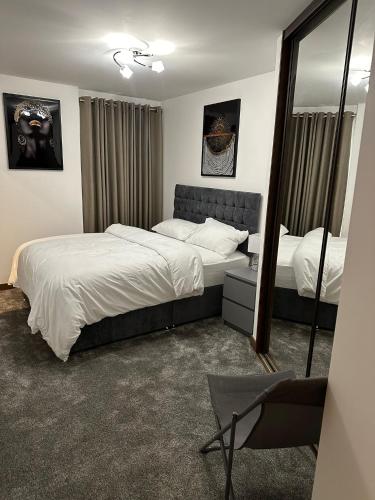 Un dormitorio con dos camas y un espejo. en JEMNACYA Apartments, en Kent