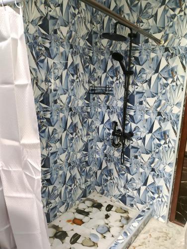 a bathroom with a blue and white tiled wall at Golden Heart in Batumi