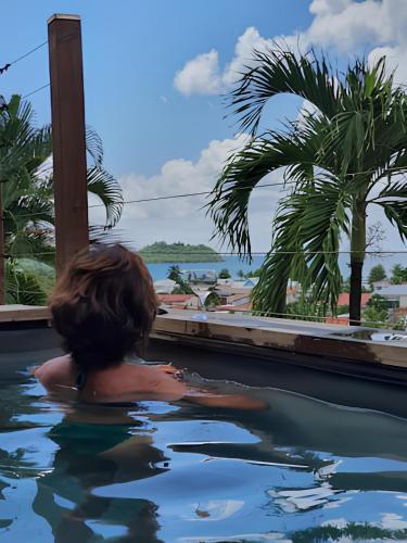 a child in a swimming pool looking out at the ocean at Terrasses avec vue Ilet Ramier in Les Trois-Îlets