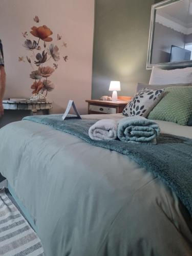 a bedroom with a bed with a blanket and a mirror at Grace B&B in Potchefstroom
