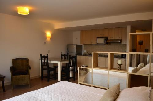Habitación con cama y cocina con mesa en Majuto en San Carlos de Bariloche