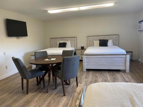 a room with two beds and a table and chairs at The Patch Lodge in Warroad
