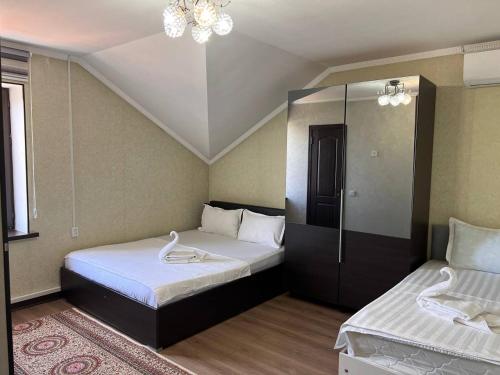 a bedroom with two beds and a chandelier at Гостевой дом Датка in Talas