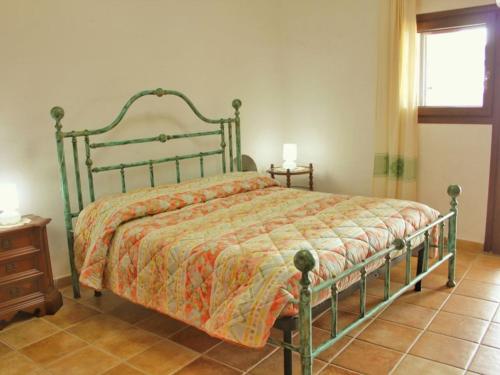 a bedroom with a bed with a green frame at Villa Erika 25 mt dalla Spiaggia in Villasimius