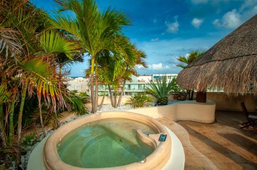 a hot tub on a resort with palm trees at Porto Playa Condo Hotel and Beach Club in Playa del Carmen
