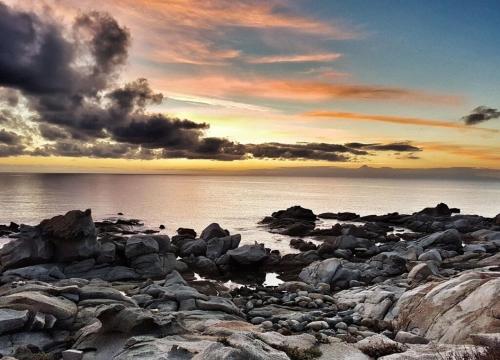 a group of rocks on a beach at sunset at Villa Erika 25 mt dalla Spiaggia in Villasimius