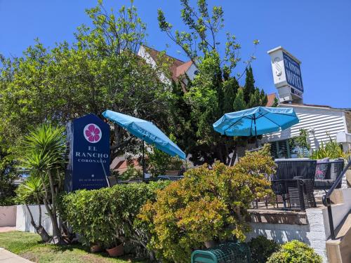 a sign for a restaurant with two blue umbrellas at El Rancho Motel in San Diego