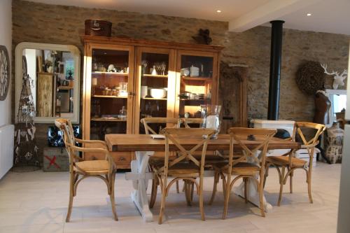 une salle à manger avec une table et des chaises en bois dans l'établissement ty and aod , maison 3 chambres belle vue mer le conquet, au Conquet