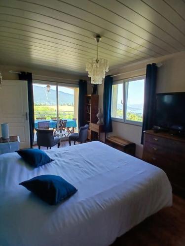 une chambre avec un grand lit blanc avec des oreillers bleus dans l'établissement Villa Le grand bleu 7 personnes Vue lac, à Saint-Jorioz