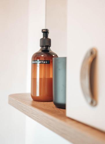 a bottle of soap sitting on a wooden shelf at Foxglove Lodge in New Quay