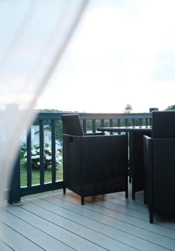 a balcony with chairs and a view of the ocean at Foxglove Lodge in New Quay