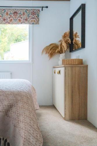 a bedroom with a bed and a mirror at Foxglove Lodge in New Quay