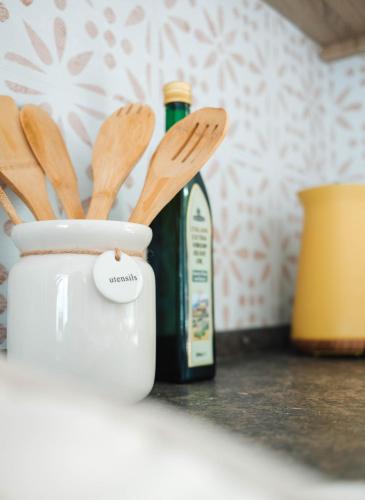 a bottle of wine sitting next to a container with wooden spoons at Foxglove Lodge in New Quay