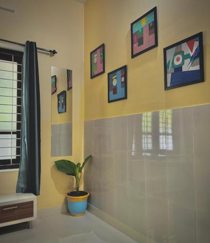 a bathroom with a potted plant and pictures on the wall at The Yellow Submarine in Varkala