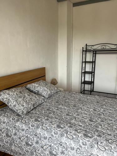 a bedroom with a bed with a blanket and a ladder at Maison de ville in Port-Sainte-Foy-et-Ponchapt