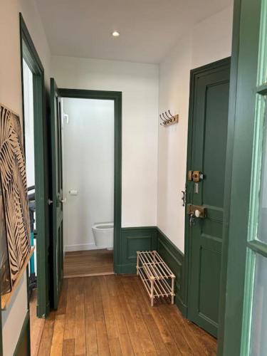 La salle de bains est pourvue de 2 portes vertes et de toilettes. dans l'établissement Appartement calme et lumineux, à Fontainebleau