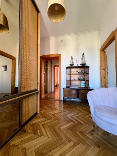 a living room with a white couch and a wooden floor at Apartament Ratuszowy in Cieszyn