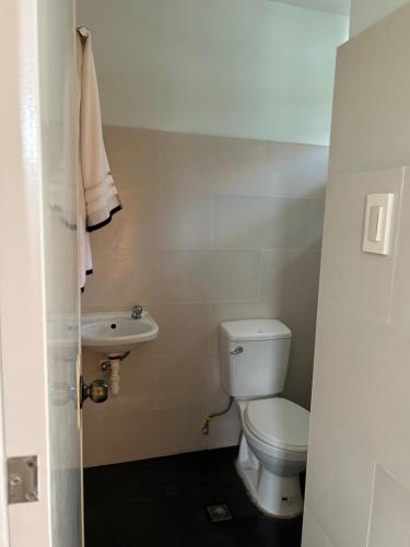 a small bathroom with a toilet and a sink at Casa Almera in Totolan