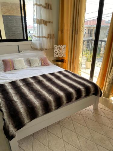 a bed in a room with a large window at Casa Almera in Totolan